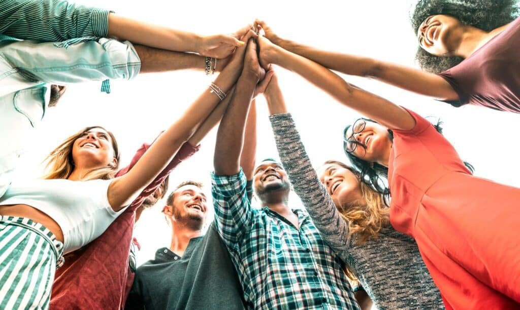 young millenial friends stacking hand on high five 2022 12 09 04 45 21 utc1600